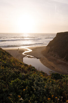 Beach at sunset with creek running through sand