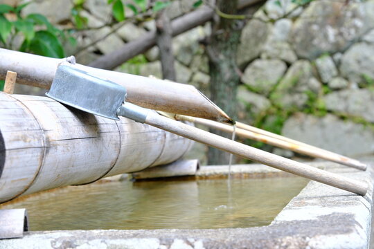 日本の神社の境内にある手水舎と竹の柄杓