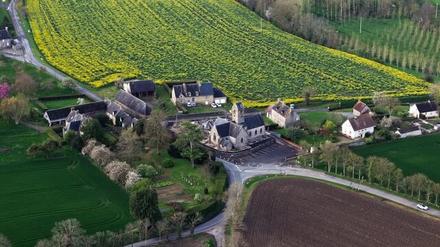 Aerial view of small village church and rural homes in Normandy, France. French countryside settlement