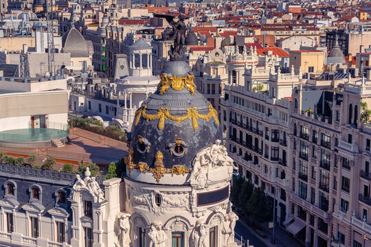 Metropolis Building dome with sculptural details above historic rooftops in central Madrid