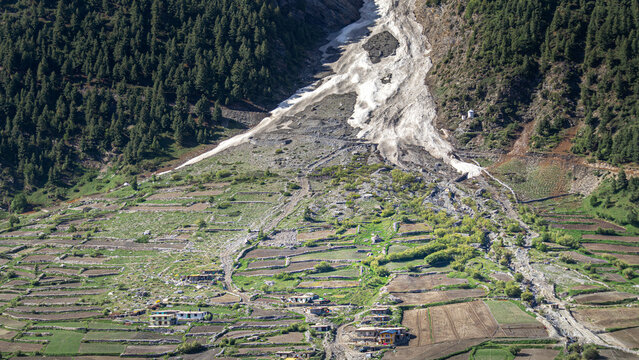 Avalanche and landslide debris flow path descending into Zanskar valley terraced village fields in Ladakh