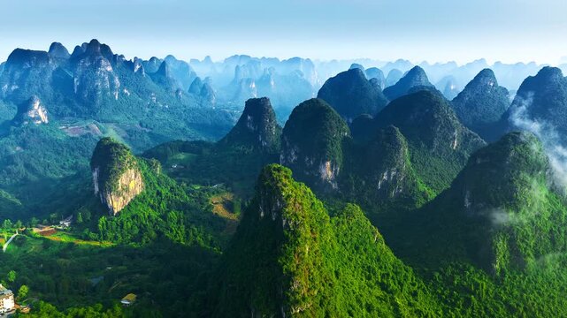 Panoramic view of karst mountain peaks covered in lush green vegetation in Guilin, Guangxi, China. Ideal for travel, tourism, and nature concept designs.