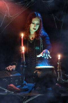 Witch casts spell, cauldron, boiling magic potion, candles, skull. Woman witchcrafting, magician girl with red hair, dressed in Halloween attire