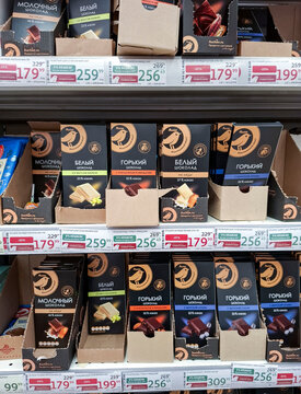 VORONEZH, Russia - April 19, 2026.Various Auchan chocolate bars arranged on display shelf in store in Russia