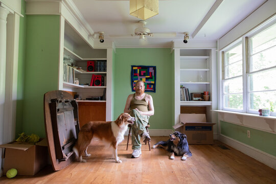 man sits with dogs while moving house