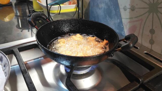 Traditional Andhra Punnugulu Deep Frying in Hot Oil on Kitchen Stove