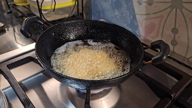 Hand Dropping Punnugulu Batter into Hot Oil for Traditional Andhra South Indian Snack