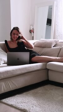 Vertical video. Home freelance. Digital work. Experienced woman entrepreneur using laptop finishing professional occupation relaxing on sofa.