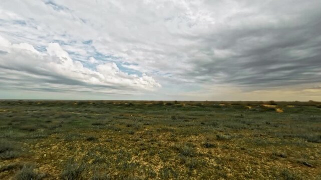 Expansive landscape view from an SUV, showcasing rolling hills and cloudy sky