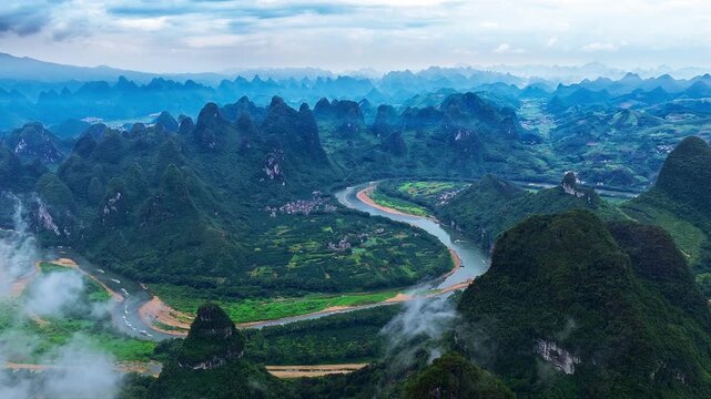 Aerial view of Li River winding through karst mountain landscape with mist in Guilin, Guangxi, China.