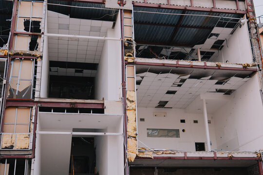 Partially demolished commercial building exposes steel framework, damaged ceilings and stripped interior during renovation