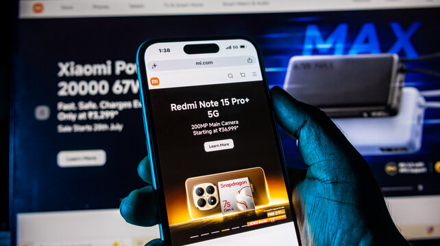 Redmi note smartphone held in hand browsing official xiaomi website.