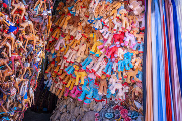colorful market shop stall filled with plush camel souvenirs leather figures fossils and hanging fabrics in a traditional bazaar in Morocco © Javier