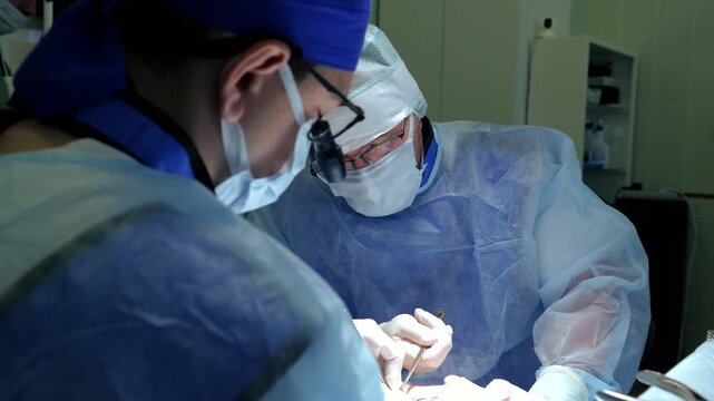 Masked surgeons performing delicate procedure over patient on sterile draped operating table under focused clinical lighting in modern hospital operating room