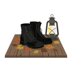 Obraz premium Black boots and lantern on wooden porch with leaves.