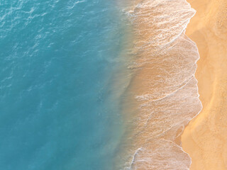 Aerial view of ocean waves gently touching sandy beach shoreline creating a calm coastal pattern. Perfect natural background for tourism promotions, summer visuals, and relaxation themes. © Hand Robot