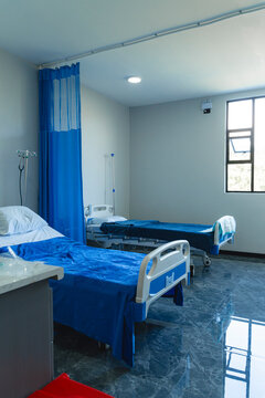 Hospital ward with two empty beds and medical equipment
