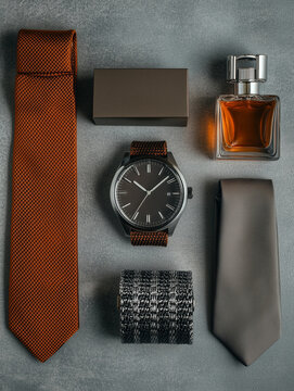 Set of male accessories - a watch, ties, belt and perfume on dark grey background as a symbol of status, success and manhood