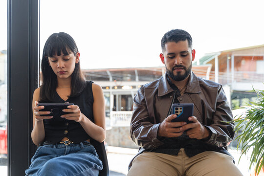 Couple ignoring each other while engrossed in smartphones