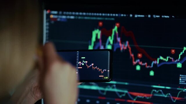 Trader Analyzing Stock Market Charts On Smartphone Screen And Monitor. Financial Data. Analytics And Business Strategy 