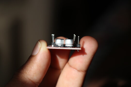SMT electrolytic capacitors on motor driver board held in the hand