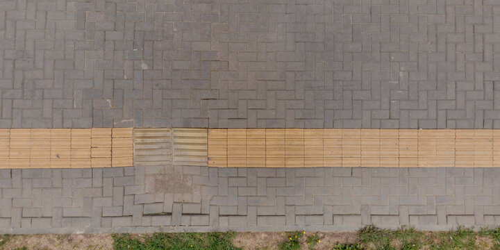 top view of surface of pedestrian path with paving slabs with the border of light and shadow