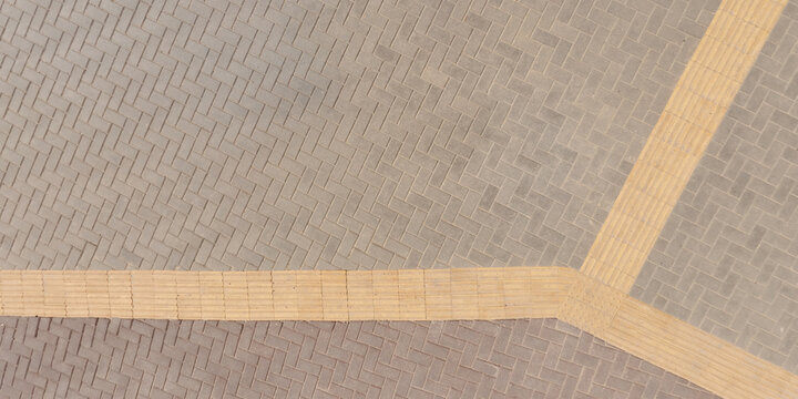 top view of surface of pedestrian path with paving slabs with the border of light and shadow