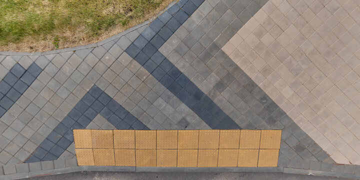 top view of surface of pedestrian path with paving slabs with the border of light and shadow