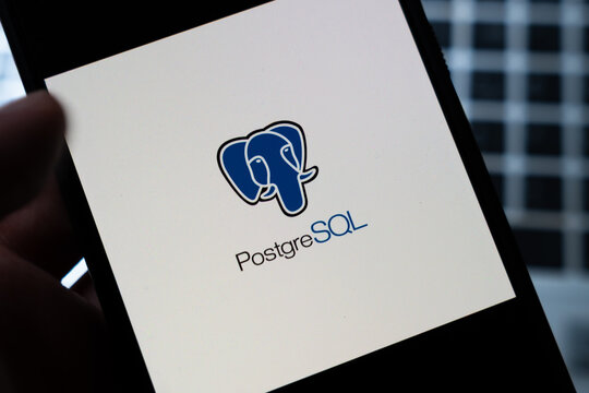 Warsaw, Poland - July 26, 2026: PostgreSQL open source relational database logo displayed on smartphone screen held in hand against dark blurred background