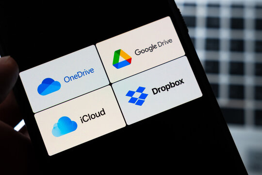 Warsaw, Poland - July 26, 2026: Cloud storage apps OneDrive Google Drive iCloud and Dropbox displayed on smartphone screen held in hand against dark background