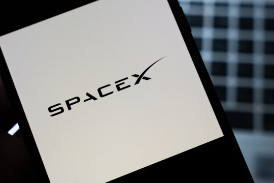 Warsaw, Poland - July 26, 2026: SpaceX logo displayed on smartphone screen held in hand against dark blurred background, illustrating private space industry brand