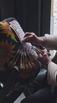 Bobbin lace. A traditional lacemaker creates lace using a traditional process introduced by Azorean settlers; a handicraft available for sale in the historic center of Florianópolis  vertical 4k