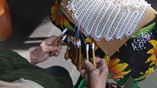 Bobbin lace. A traditional lacemaker creates lace using a traditional process introduced by Azorean settlers; a handicraft available for sale in the historic center of Florianópolis 