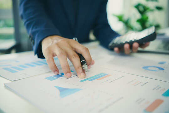 Financial planning with business professional using calculator and reports to analyse performance control budgets forecast results support investment decisions and drive sustainable growth.