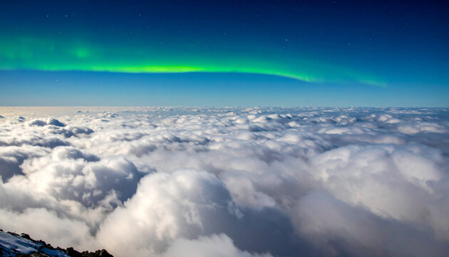 Aurora borealis over sea of clouds from mountain top at night