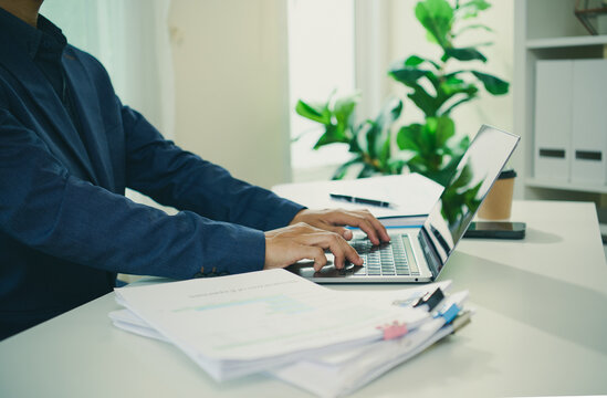 Financial reporting workflow with business professional typing on laptop beside organised documents to analyse records improve productivity support compliance and guide informed decisions.