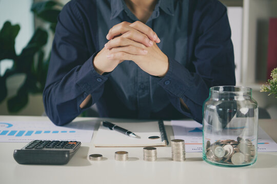 Savings growth planning with business professional reviewing stacked coins calculator reports and money jar to manage budgets build financial security and support long term wealth goals.