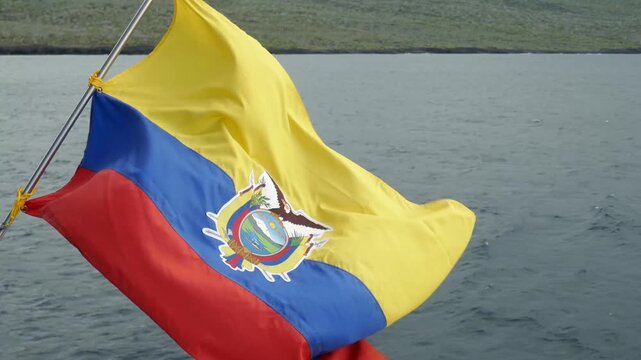 Ecuador flag waving with wind currents on back of boat on the ocean