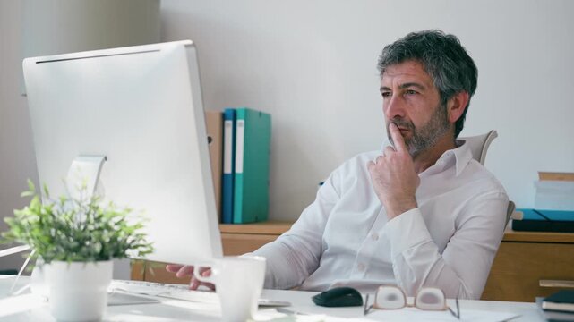 Video of concentrated elegant businessman working on a computer in the office