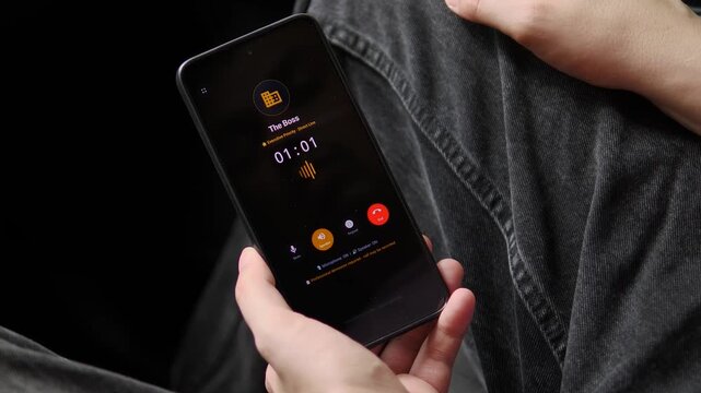 Employee takes a priority call from a boss on a smartphone, reflecting remote management, executive communication and the pressure of always-connected work culture.