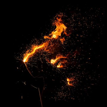 Fiery sparks and flames erupting from a sparkler in the dark