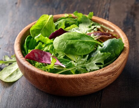 fresh spring mix salad leaves in wooden bowl with spinach arugula and lettuce