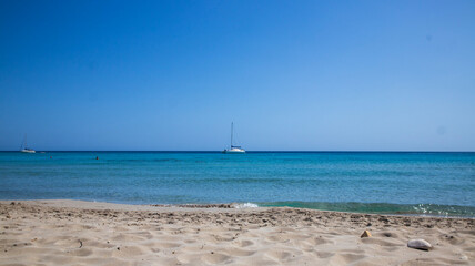 Fototapeta premium Sailboat Sailing on Calm Ocean under Clear Blue Sky