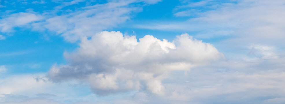 White fluffy cumulus cloud in bright blue sky panoramic view