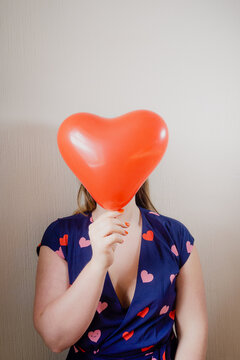 Woman holding a red heart balloon