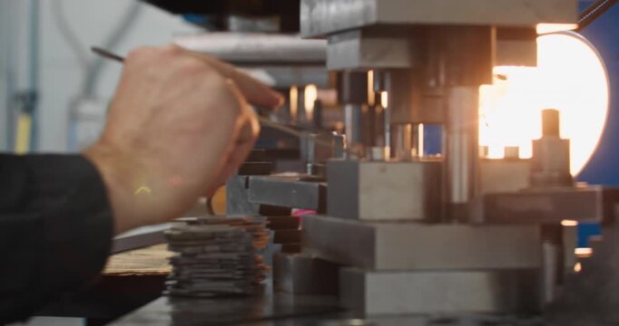 Punch press machine forming metal parts from metal blanks during a stamping operation in an industrial production facility
