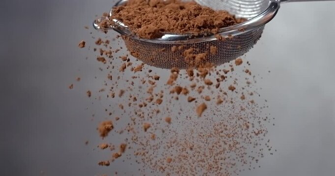 Cocoa powder falling from a sieve slow motion