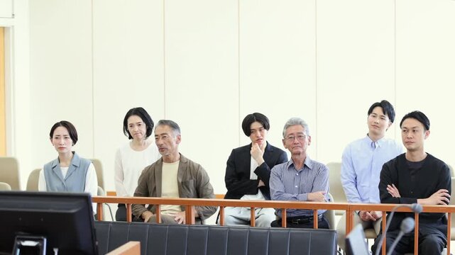 法廷の傍聴席で裁判を見守るさまざまな世代の人々