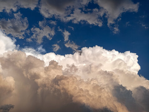 A large thundercloud over the city.  Color photograph of a large rain cloud over a city during the daytime.