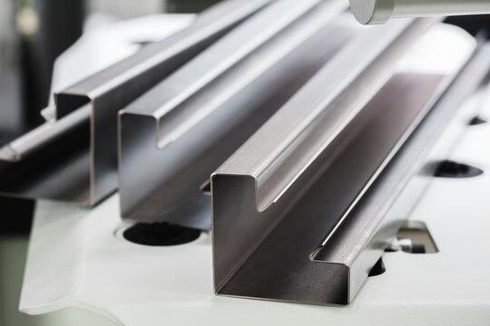 Industrial concept. sheet metal detail manufactured using an industrial bending machine. tech industrial technology background